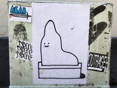 ACAB sticker besides a cartoonish illustration sticker