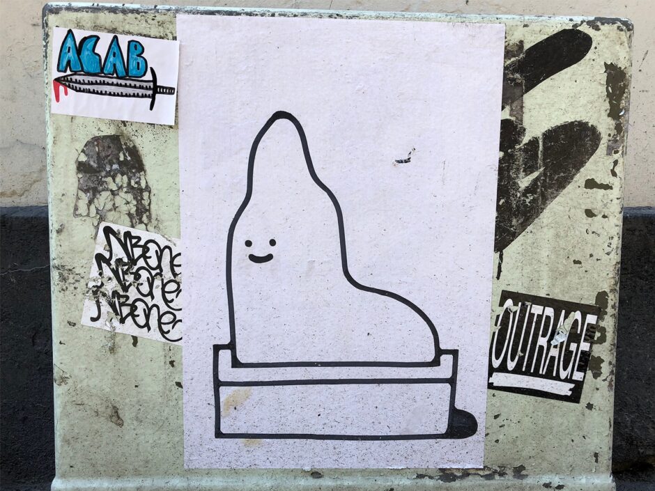 ACAB sticker besides a cartoonish illustration sticker