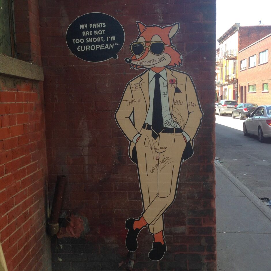 Man sized fox wearing a suit wheat paste on brick wall