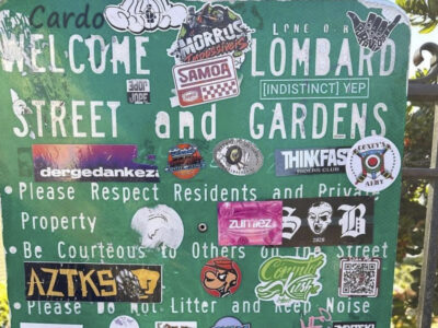 Multiple stickers on a park welcome sign