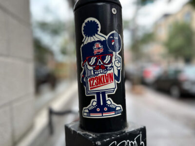 123KLAN sticker on parking post
