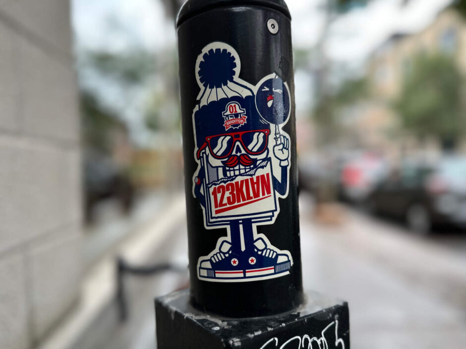123KLAN sticker on parking post